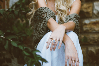 Stacked rings worn with a knit cardigan