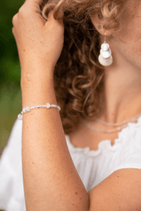 Model wearing a Guhas Gems and Jewelleries earring and beaded bracelet