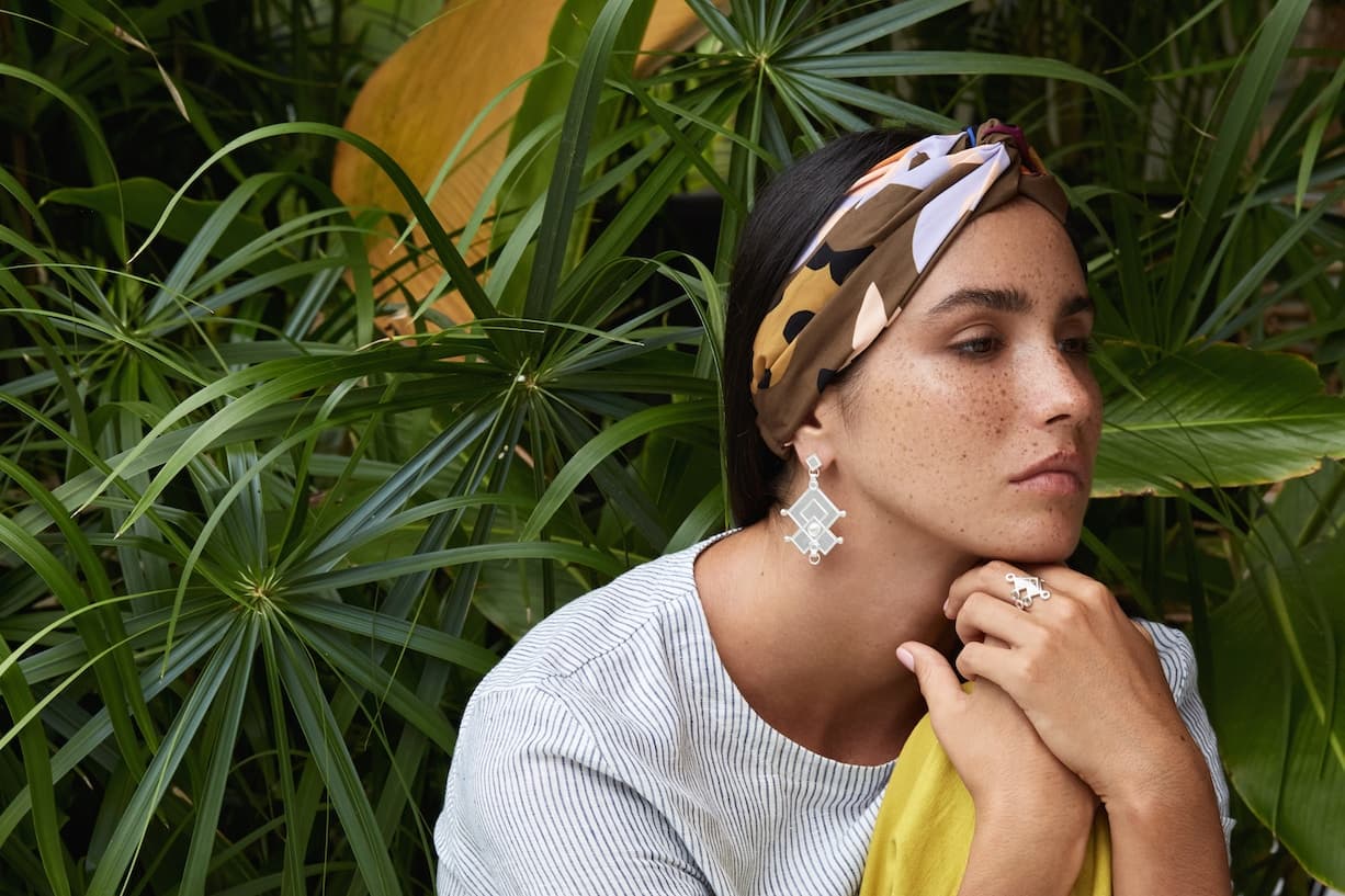 Woman in a printed headscarf wearing Guhas Gems and Jewelleries drop earrings
